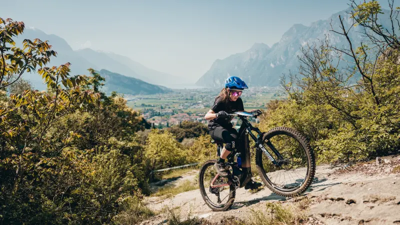 A woman rides an e-bike up a mountain